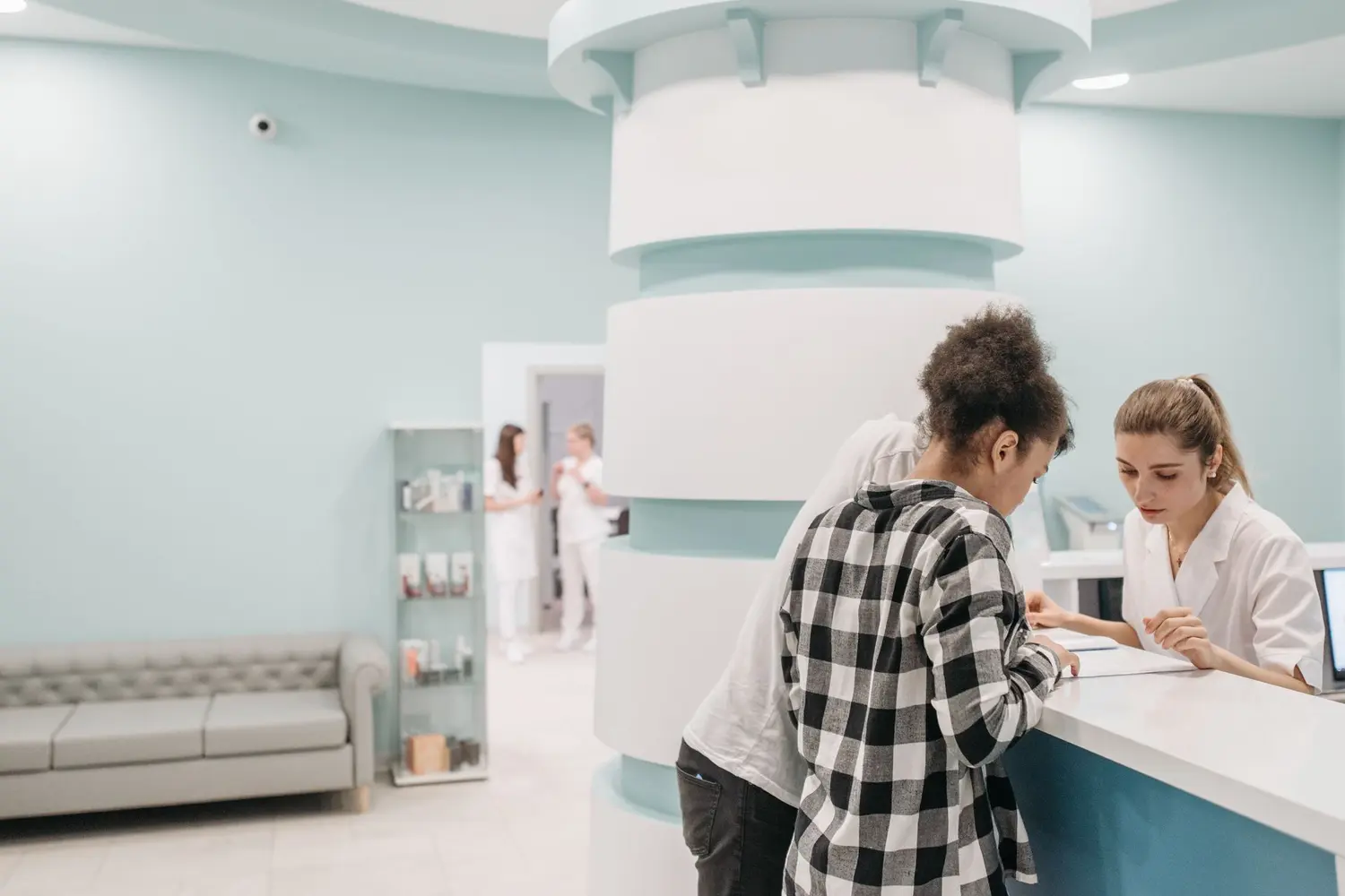 A receptionist at Riverside Family Practice checking in a new patient at the front desk.