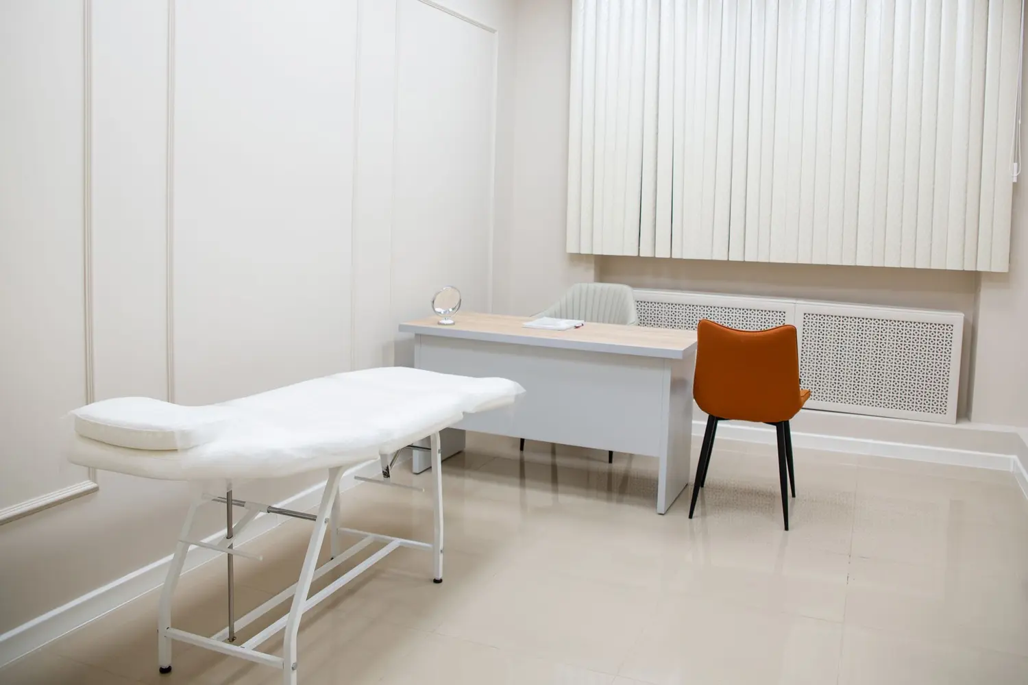 A clean, bright exam room at Riverside Family Practice with a paper-covered exam table and doctor's desk.