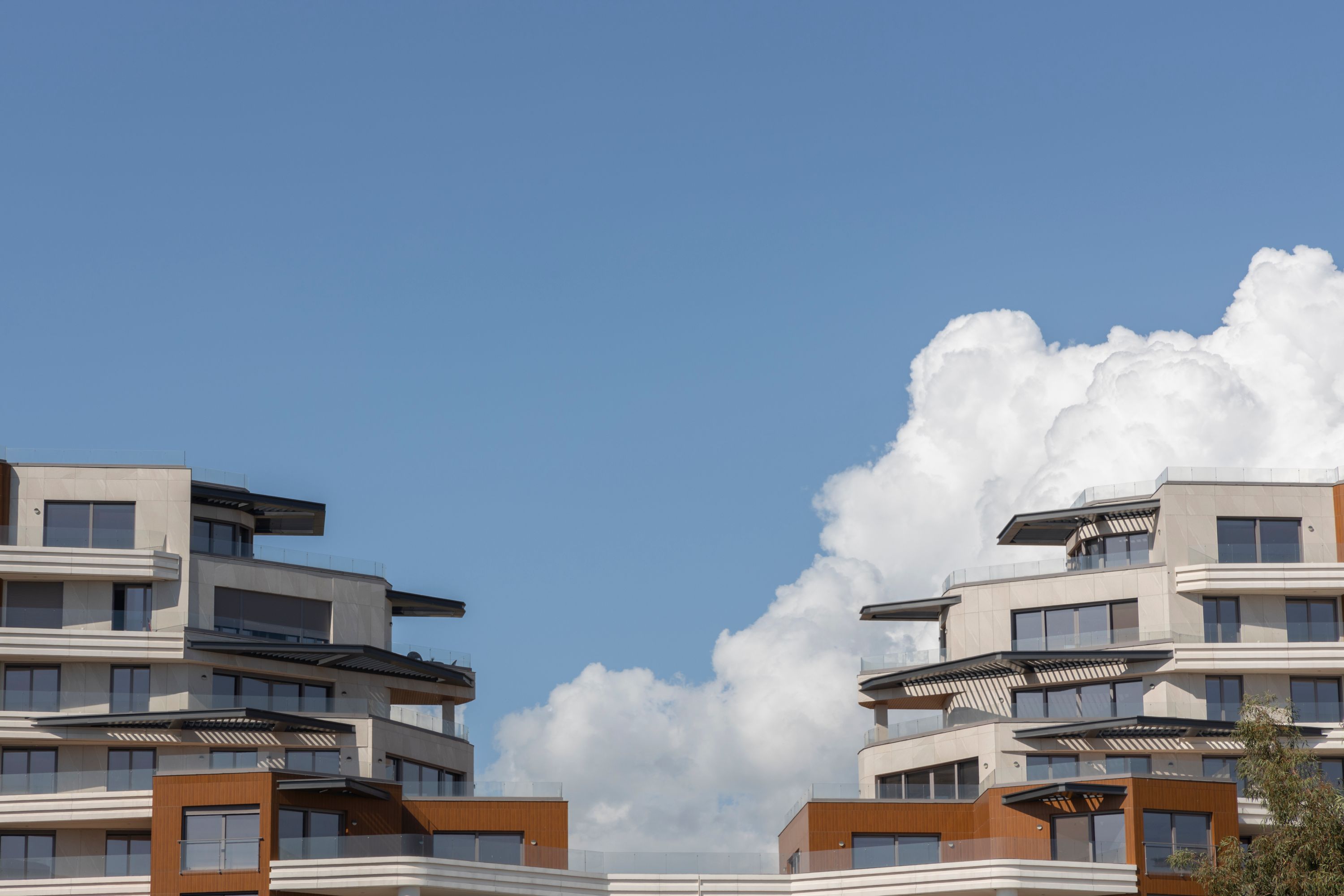 A modern apartment building exterior with balconies under a clear sky.