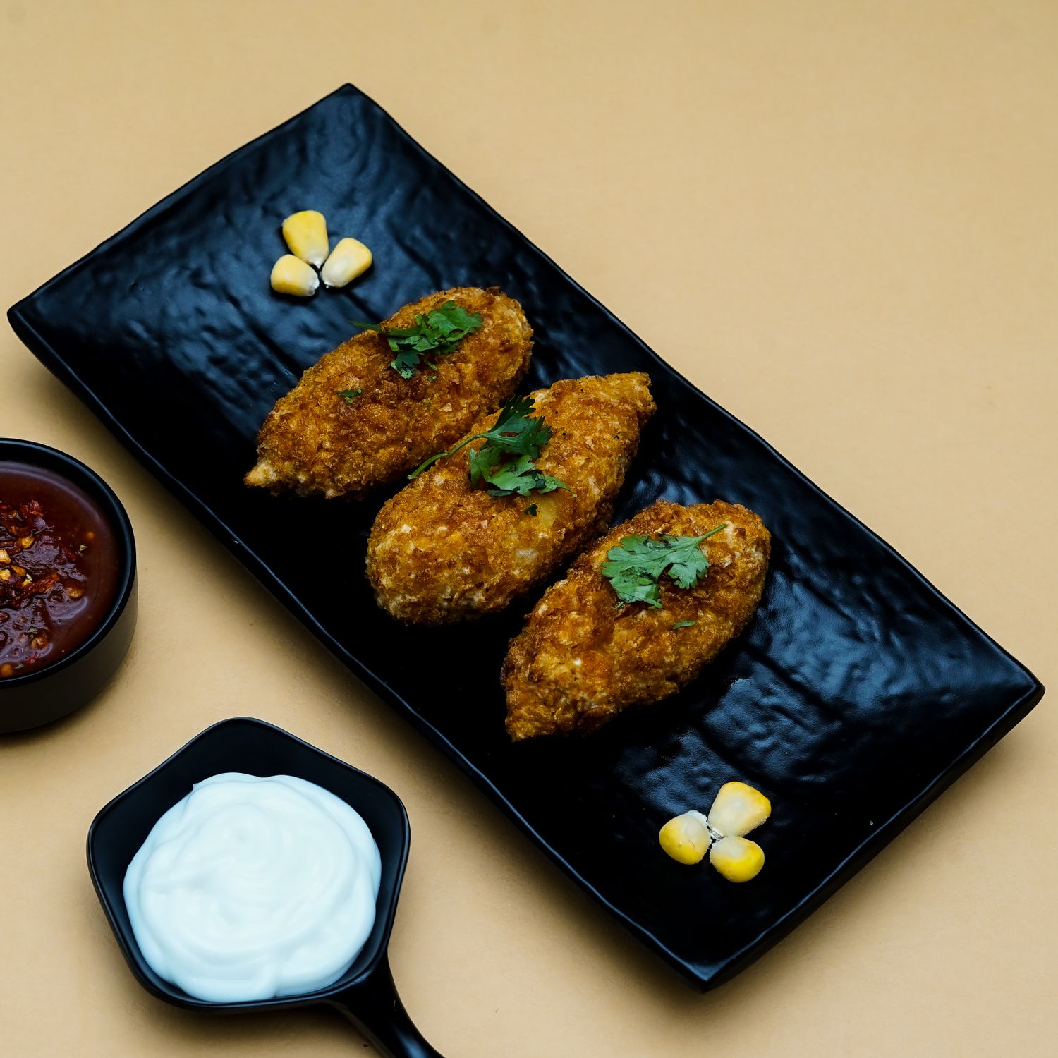 A plate of golden pierogi with sour cream.