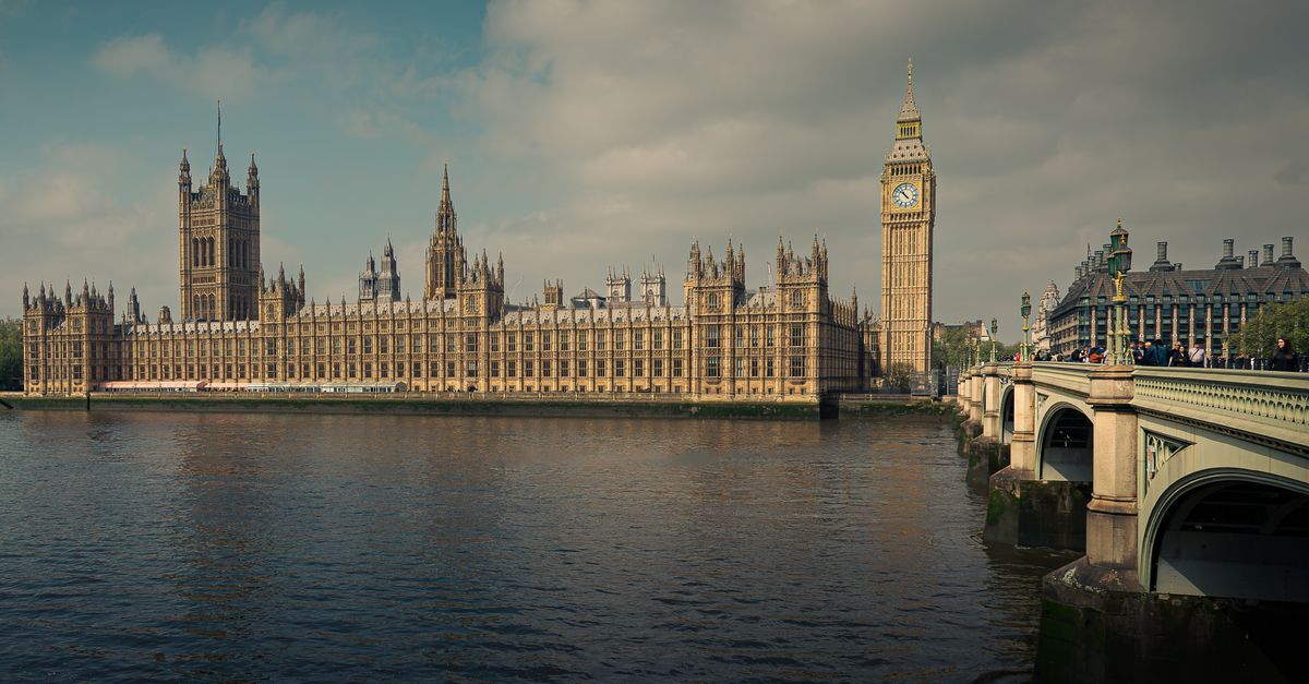 Big Ben and the Houses of Parliament in London, with the River Thames and Westminster Bridge at sunset.